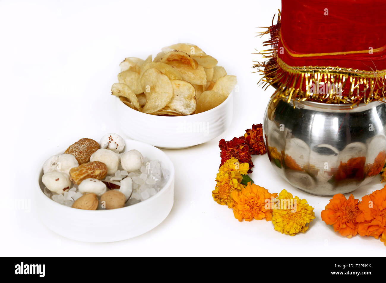 Kalash avec noix de coco et chunni avec décoration florale de navratri pooja. Portrait de fruits secs et les chips de pomme de terre dans le bol. Isolé sur blanc la ba Banque D'Images