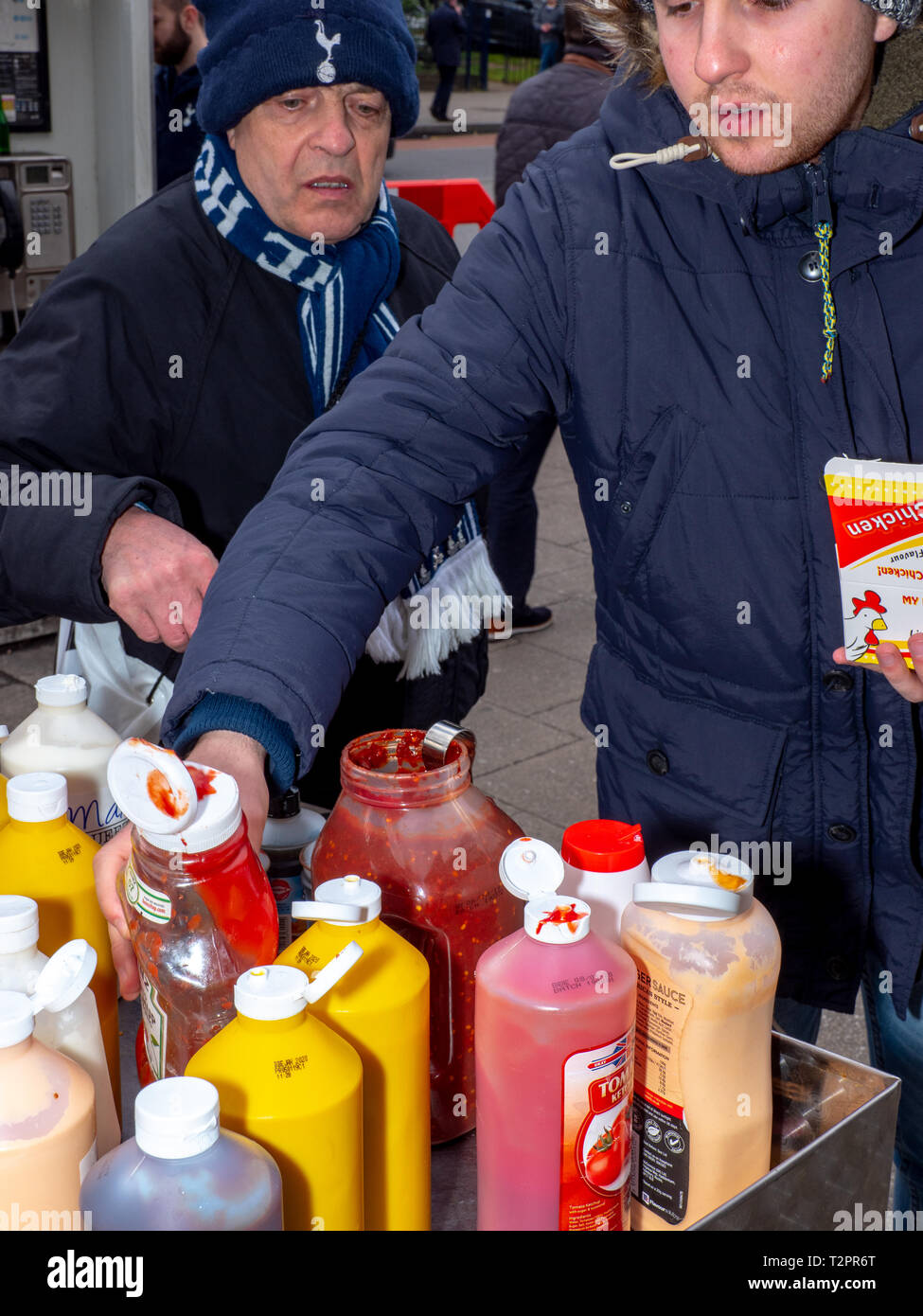 Tottenham Hotspur fans s'appliquent à leur sauce la malbouffe avant un match au nouveau stade. Banque D'Images