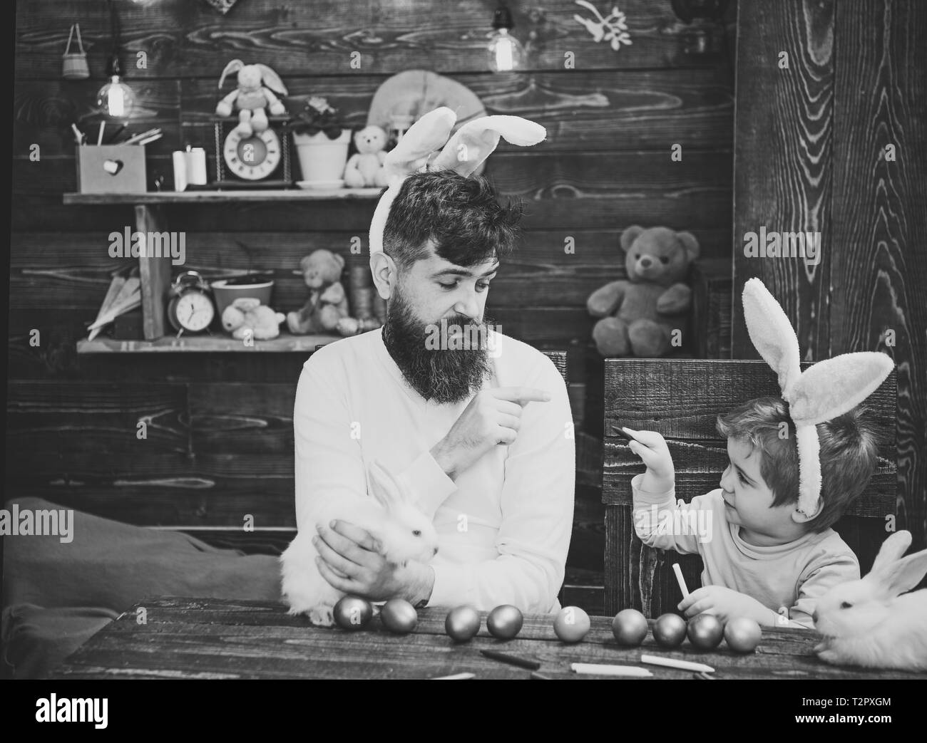 Famille Pâques avec de fausses oreilles de lapin. Père et de peinture pour enfants des oeufs de Pâques. Banque D'Images
