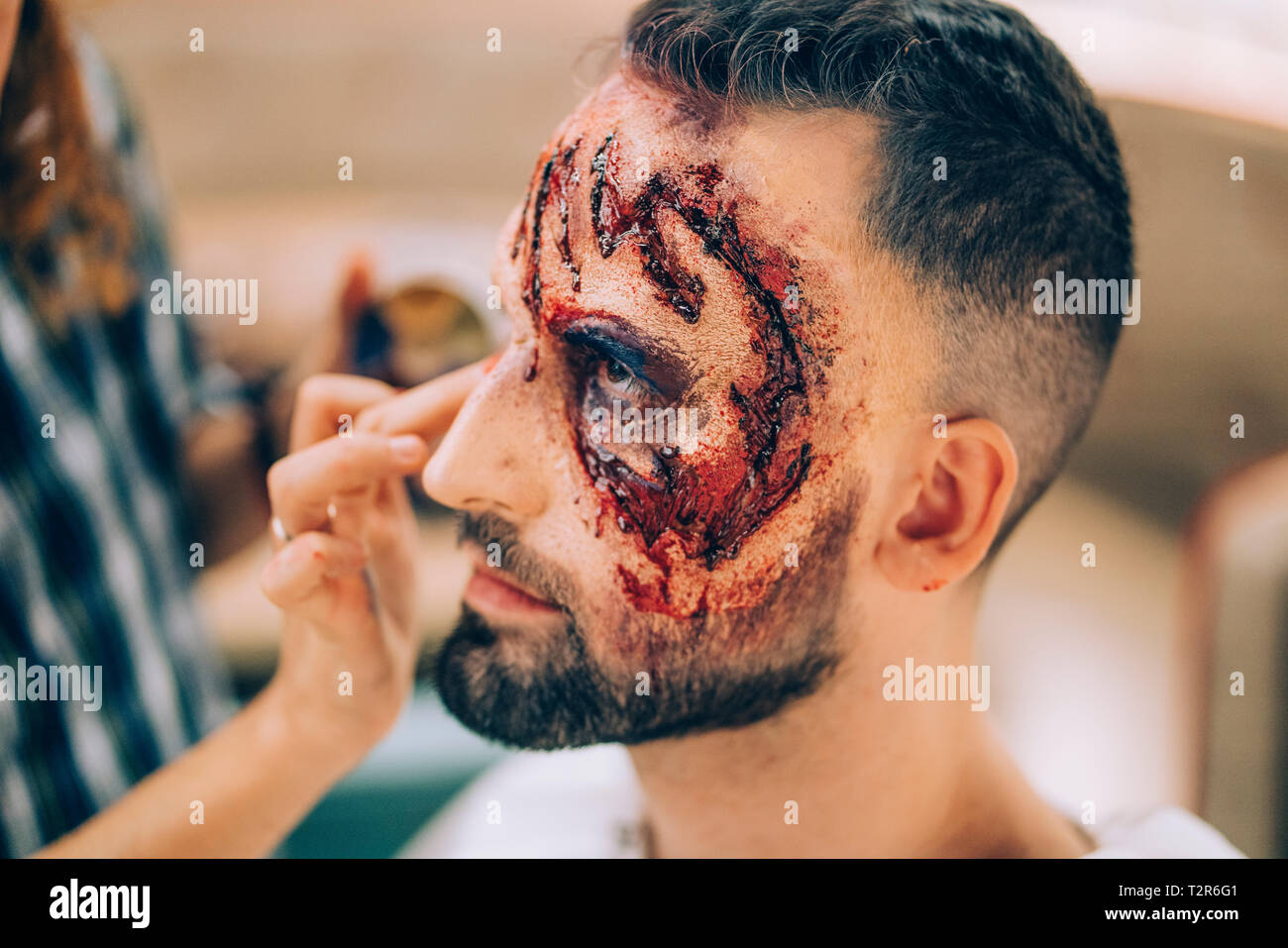 Homme avec du maquillage sur son visage avec des blessures et du sang. Banque D'Images