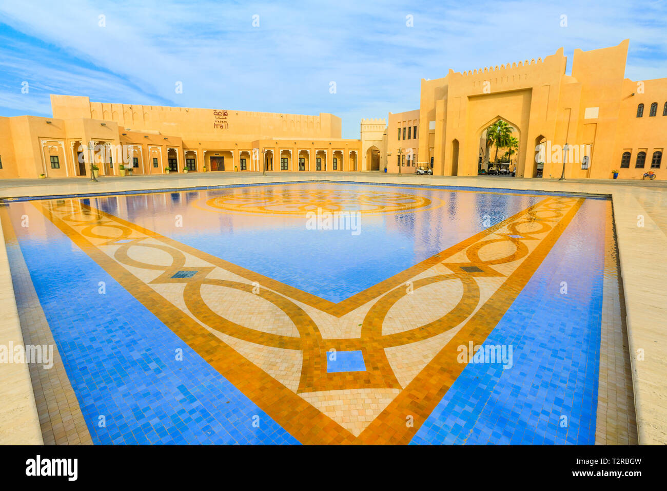 Doha, Qatar - 17 Février 2019 : la galerie marchande de Katara Katara Cultural Village reflétant dans une piscine carrelée avec une fontaine dans le quartier de la baie de l'Ouest, au Qatar, au E Banque D'Images