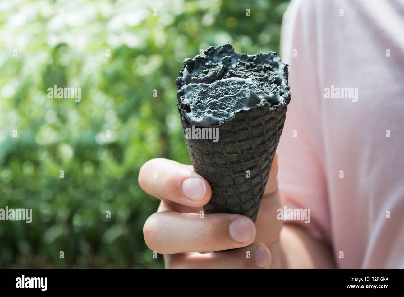 Dans l'adolescence part mordre gothique black ice-cream. Les sucreries d'été moche de la nourriture. Close up. Banque D'Images