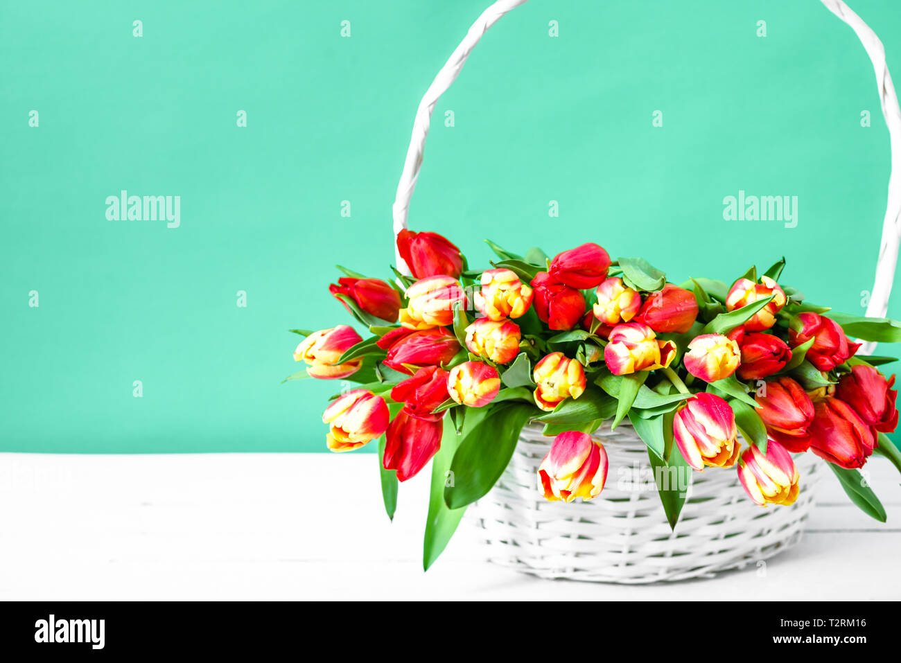 Bouquet de printemps tulipe fleurs dans un panier sur la table en bois Banque D'Images