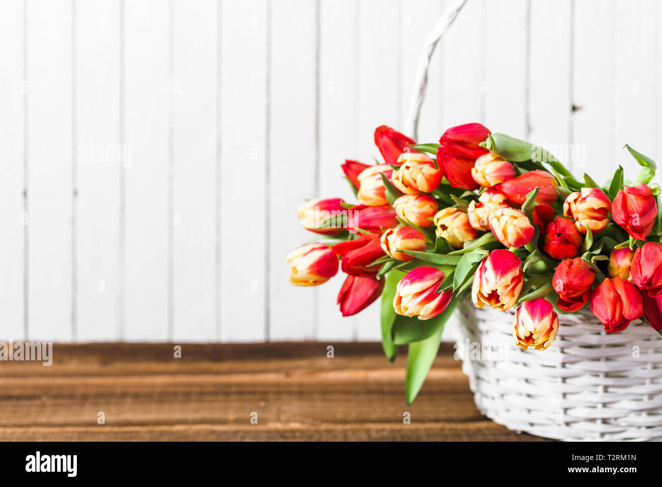Bouquet de tulipes dans un panier sur la table en bois Banque D'Images