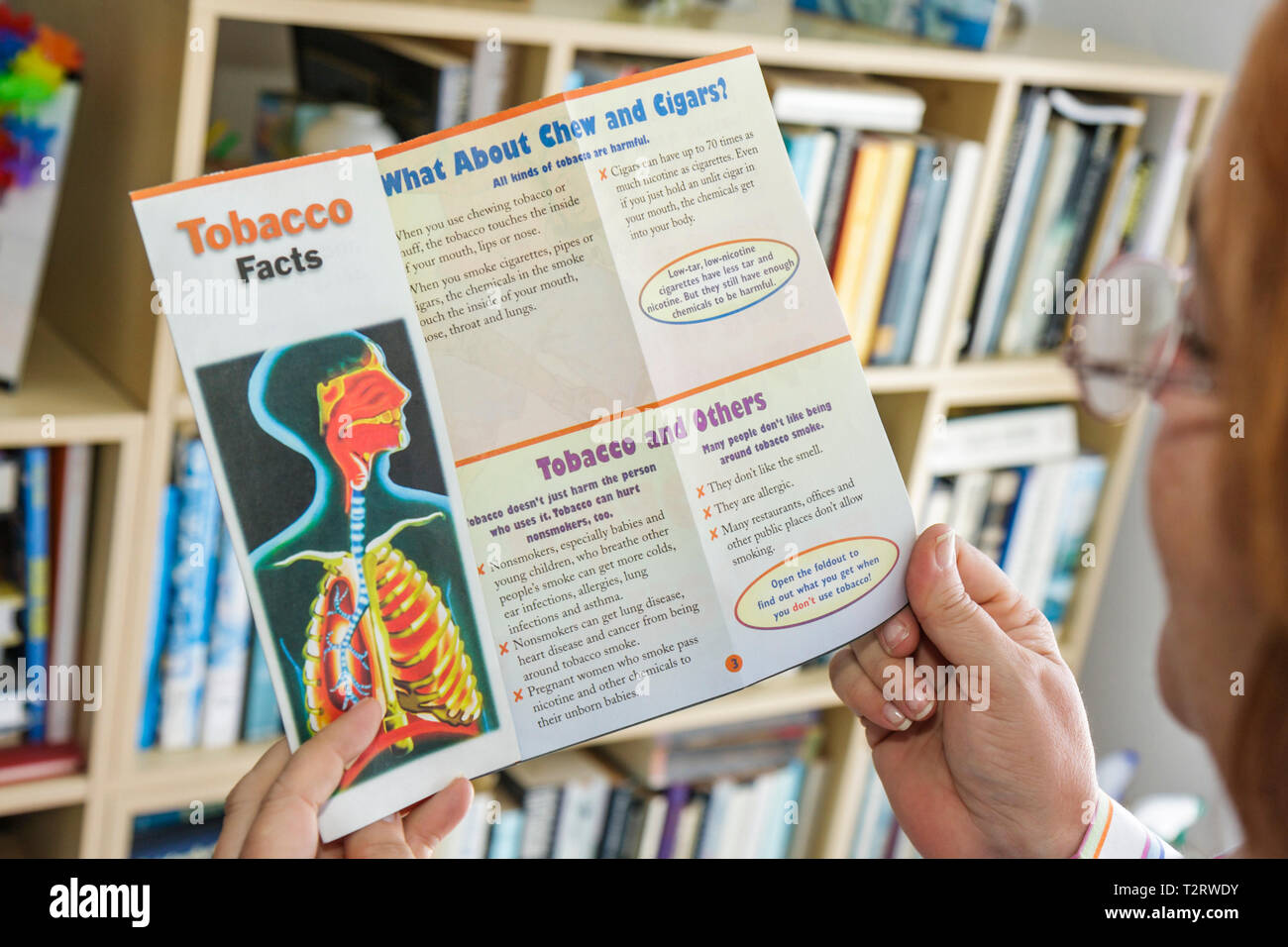 Miami Beach Florida,femme hispanique femmes,lecture,brochure brochures dossier dossiers brochure dépliants information,tabac,faits,information,ant Banque D'Images