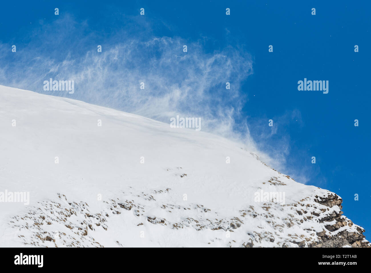 Fort naturel de bourrasques de vent neige tourbillonnante en montagne, ciel bleu, rock Banque D'Images