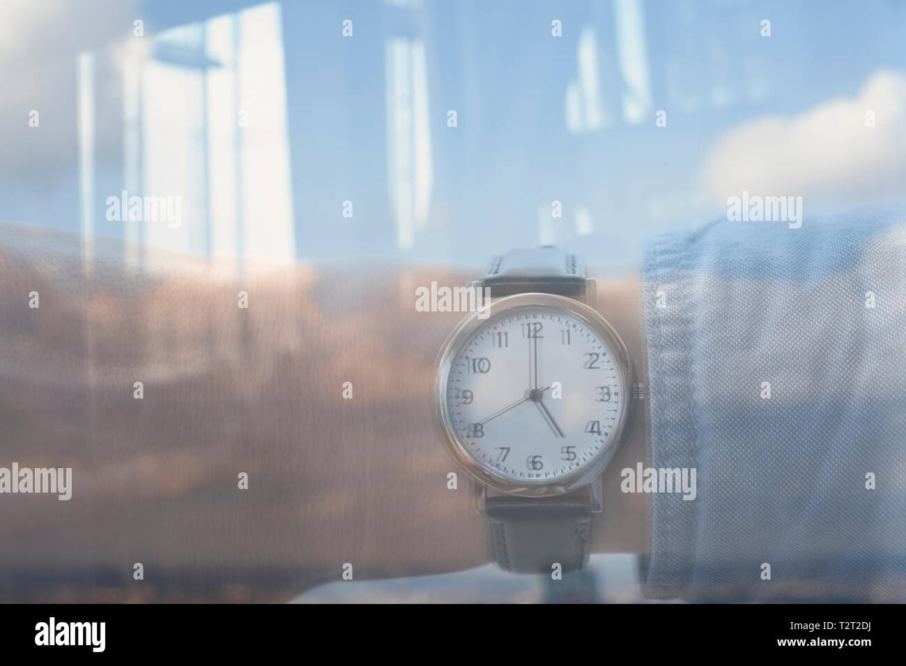 Réflexion d'un homme de race blanche portant une montre indiquant l'heure 5:00 Banque D'Images