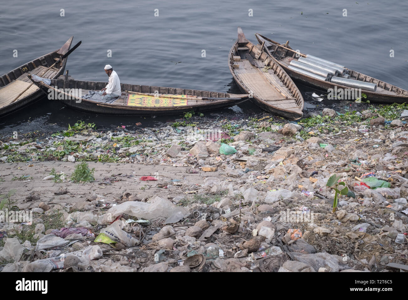 1 musulman priant sur le bateau à la banque de la rivière Buriganga polluées, Zinzira Keraniganj, district, Dhaka, Bangladesh. Banque D'Images