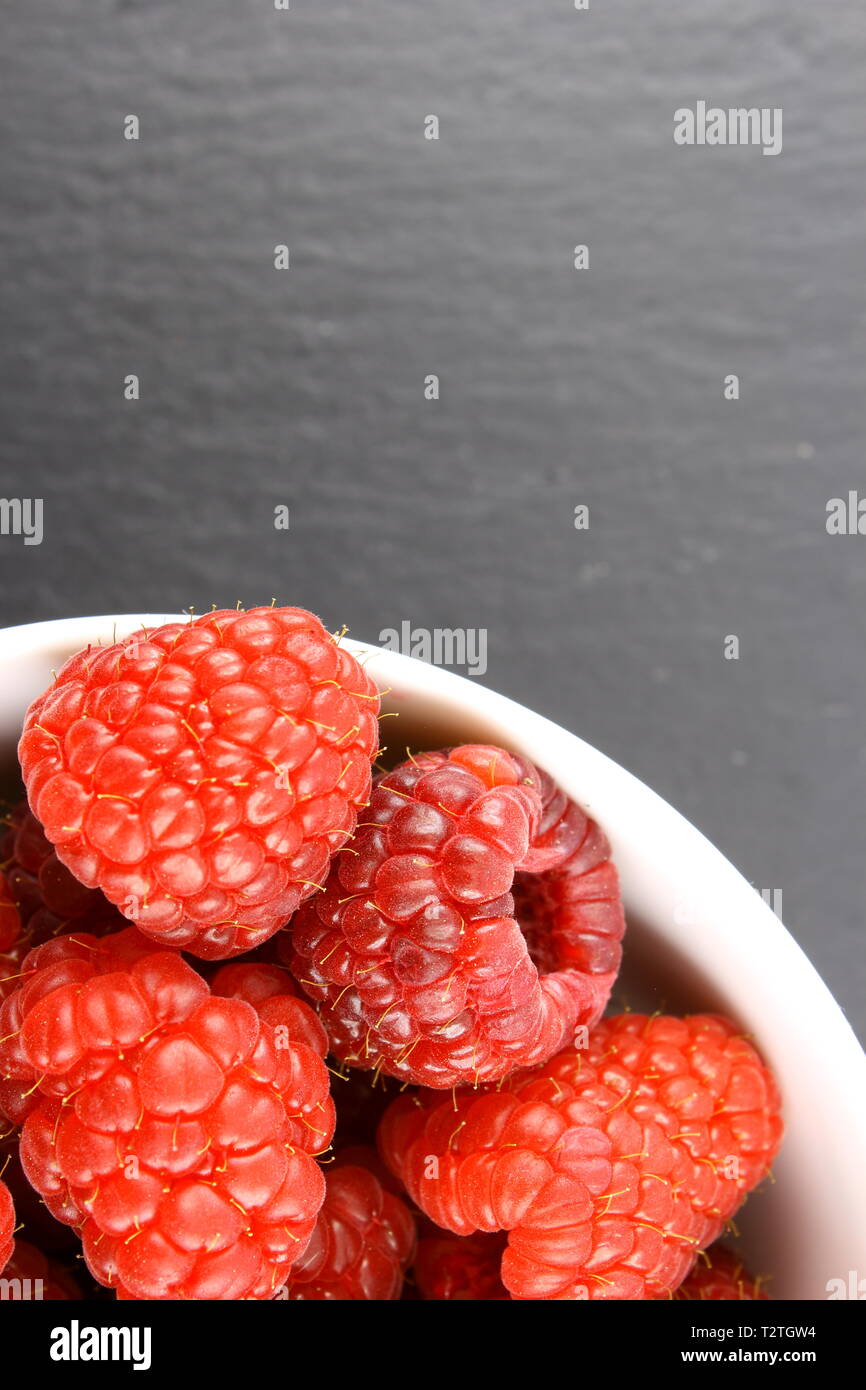 Fresh Fruits framboise rouge dans un petit bol blanc Banque D'Images