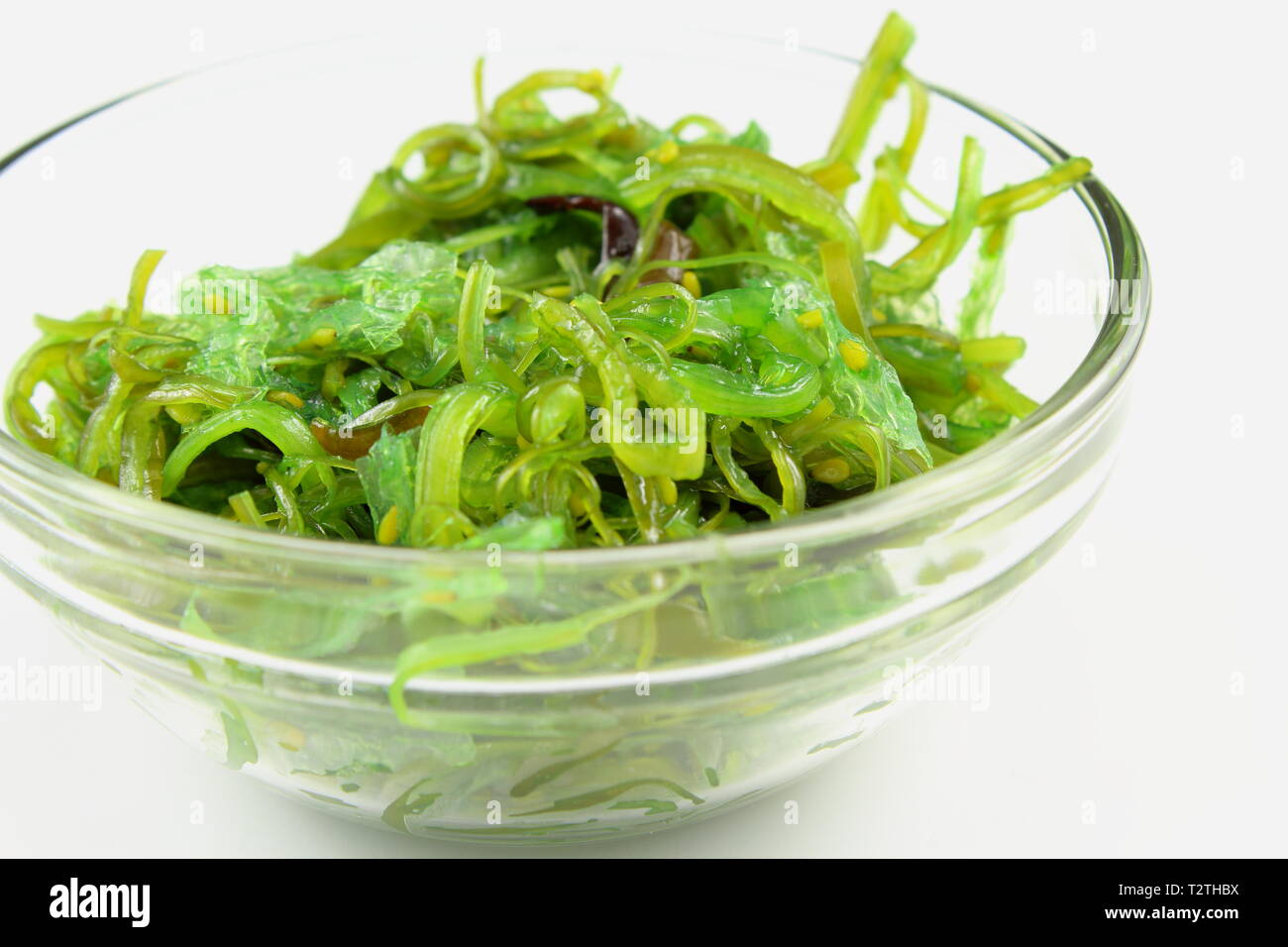 Salade de wakamé au sésame dans un petit bol en verre isolé sur fond blanc Banque D'Images