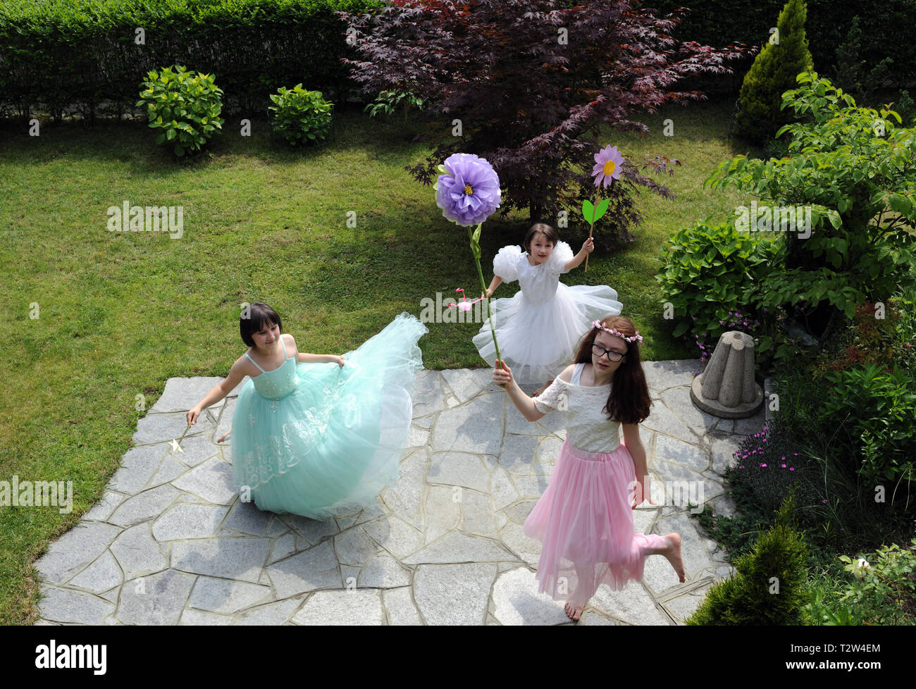 Les petites filles vêtues comme des princesses jouant dans le jardin Banque D'Images