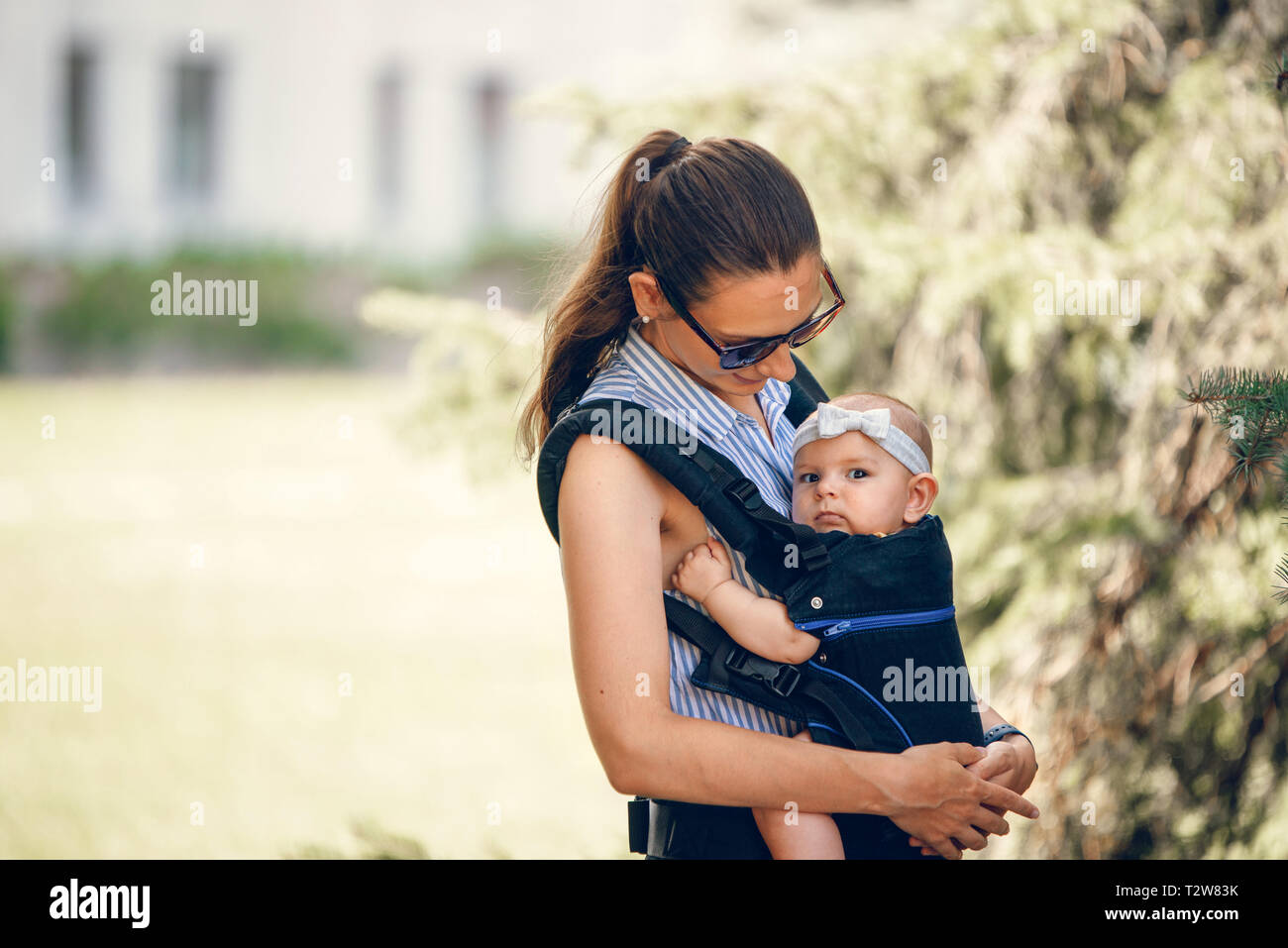 Petite fille et sa mère à l'extérieur de portage dans l'ergo carrier Banque D'Images