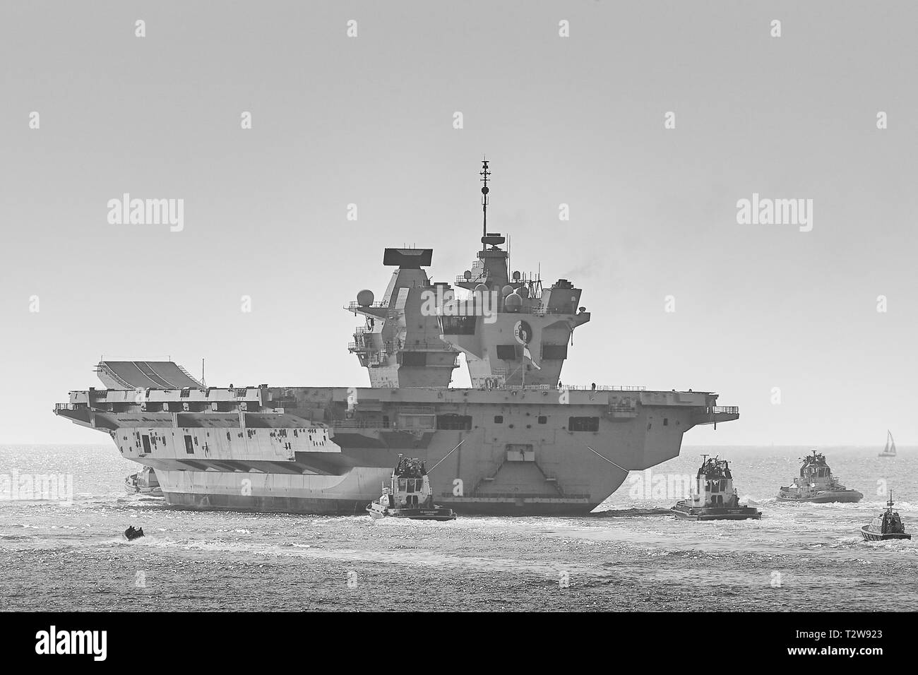 Porte-avions de la Royal Navy, le HMS QUEEN ELIZABETH, étant assisté par 3 remorqueurs à l'arrière comme elle quitte Portsmouth Pour Rosyth, en Écosse. 01 avril 2019. Banque D'Images