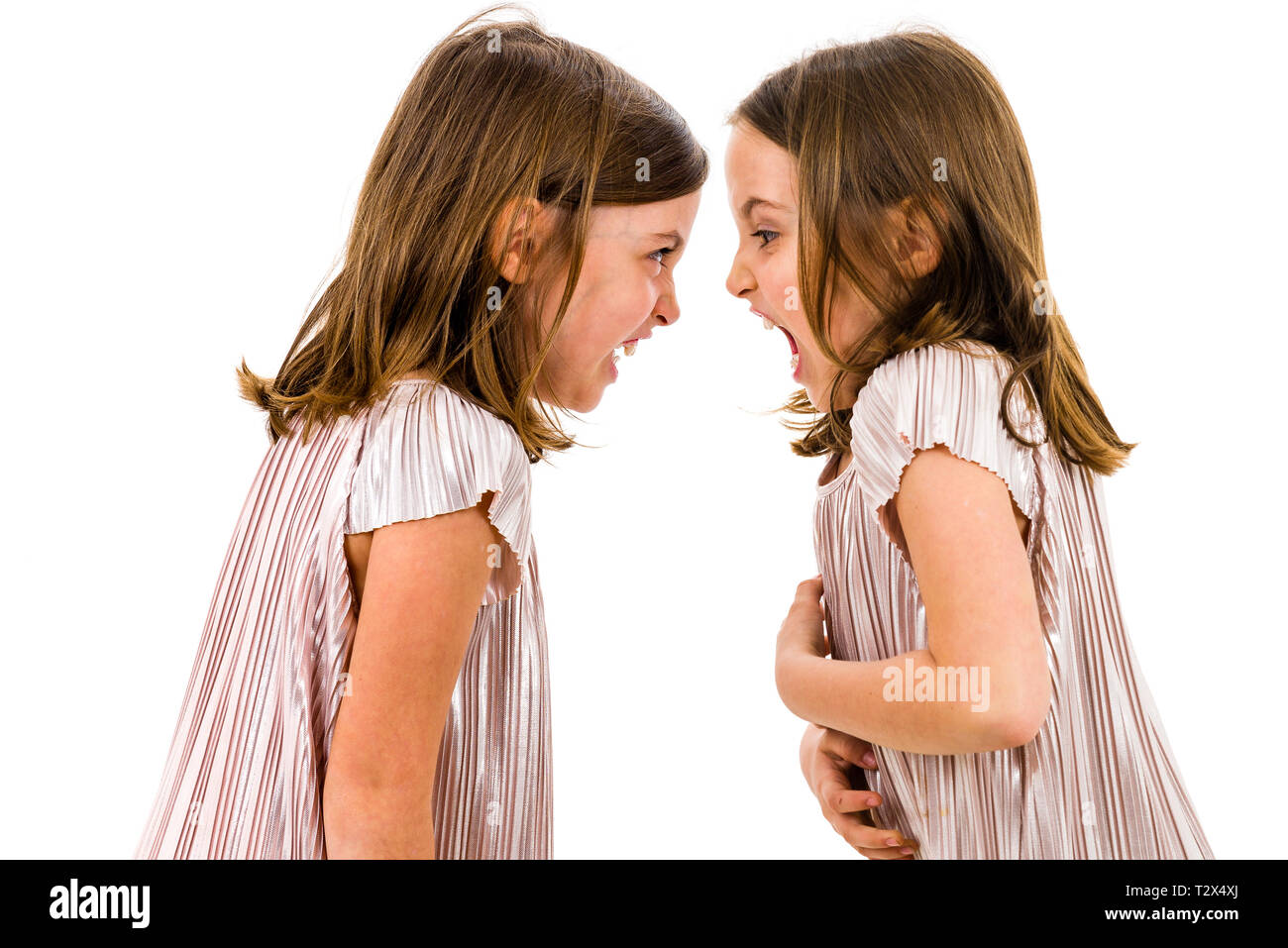 Soeurs jumelles identiques se disputent à crier après l'autre. Les filles sont en colère crier, crier et se disputer avec expression des émotions sur des visages. Fron Banque D'Images
