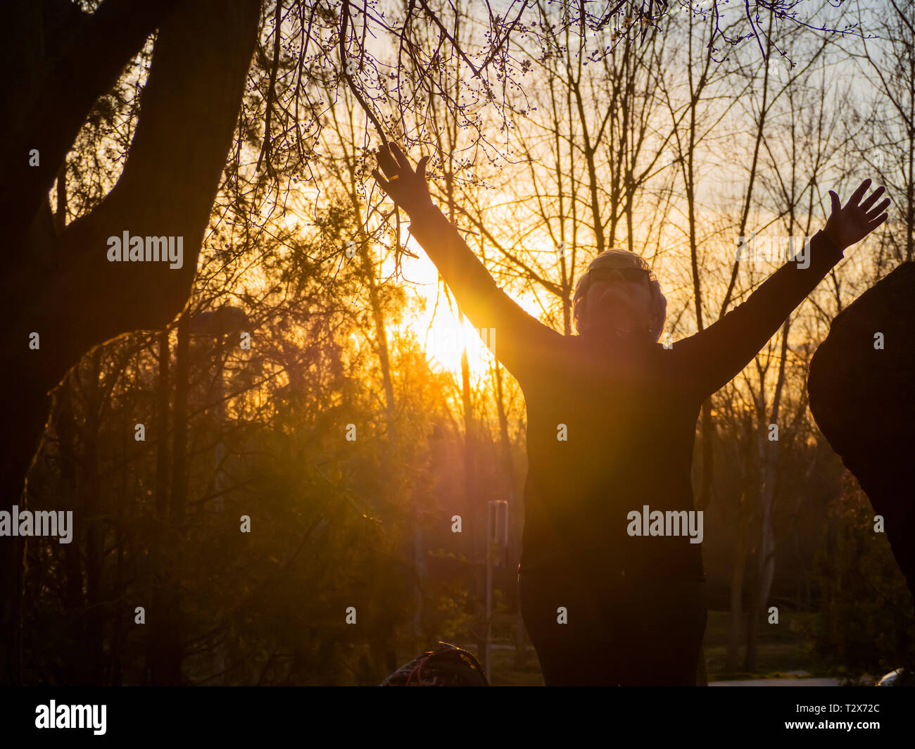 A senior woman practicing yoga au coucher du soleil dans un parc urbain Banque D'Images