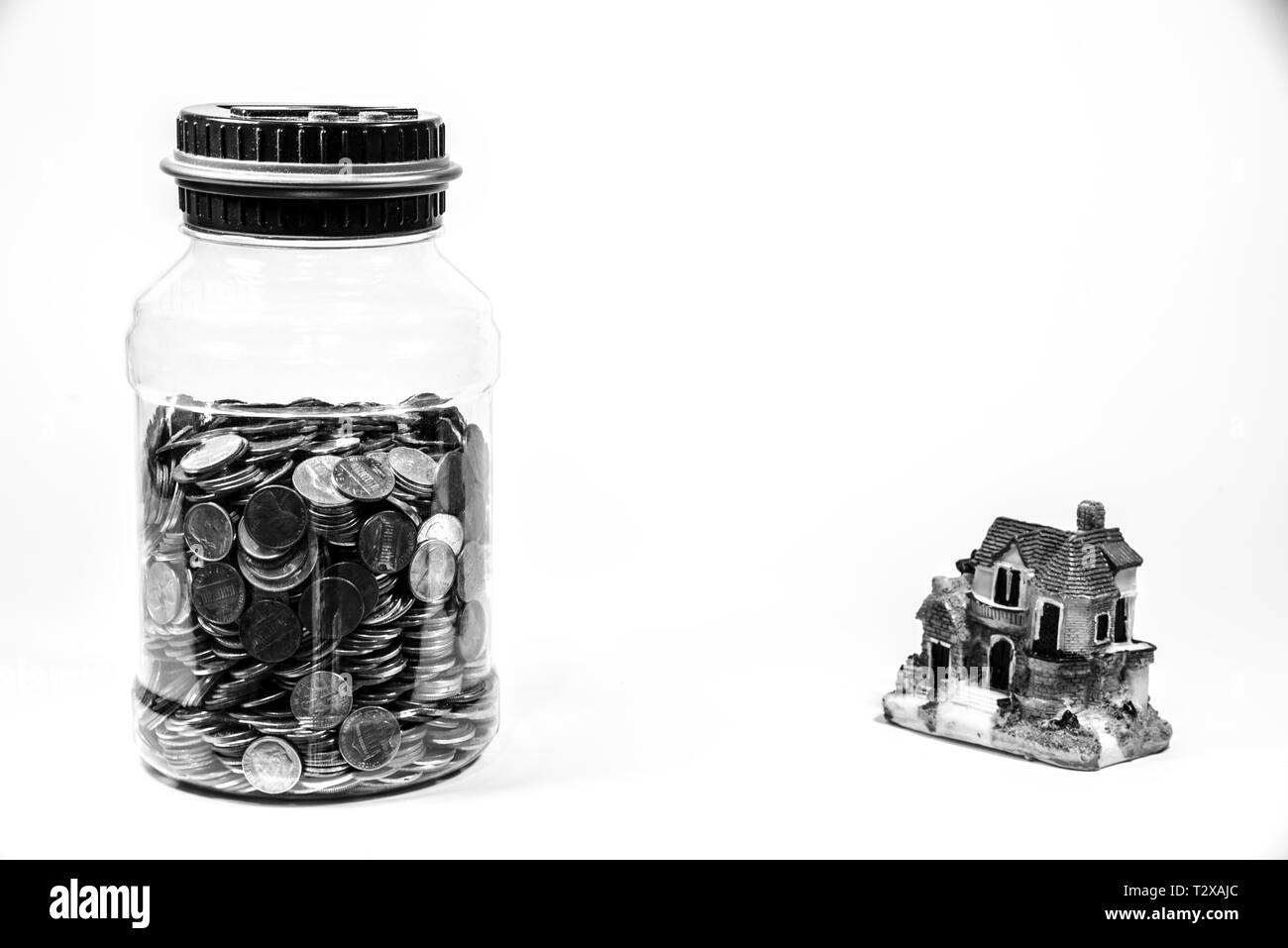 Pot plein de pièces d'une maison miniature représentant l'économie d'argent pour un prêt hypothécaire Banque D'Images