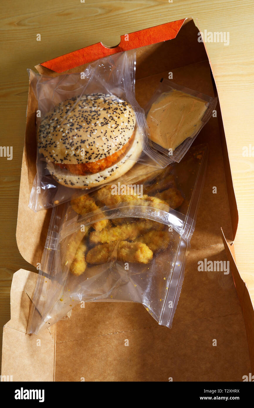 Burger de poulet repas ensemble dans l'emballage en plastique sur papier fort Banque D'Images