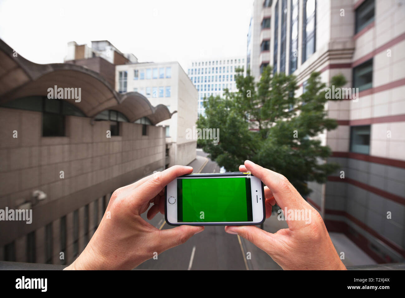 Point de vue personnel d'un homme à l'aide d'un smartphone avec un écran vert Banque D'Images