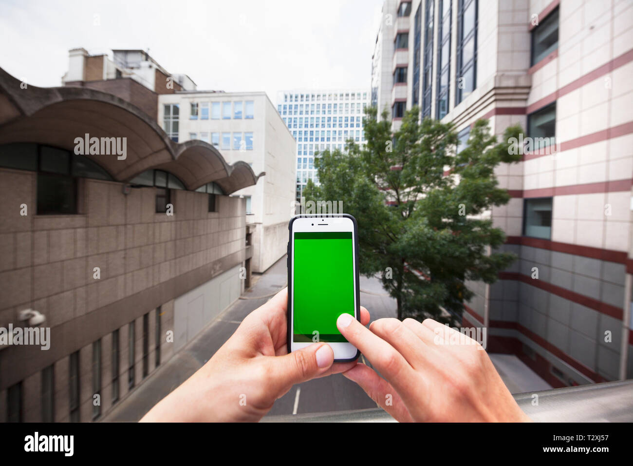 Point de vue personnel d'un homme à l'aide d'un smartphone avec un écran vert Banque D'Images