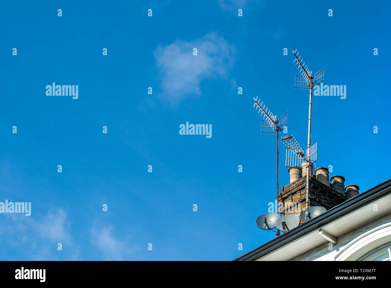 L'antenne satellite et l'antenne sur un toit de maison. Banque D'Images