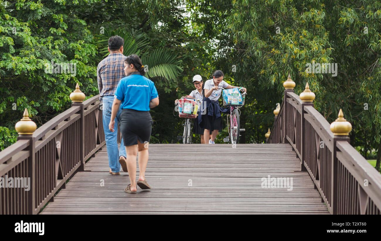 Bangkok, Thaïlande - 25 septembre 2018 : les filles Thai avec des vélos de marche sur un pont de bois vers d'autres passants dans un parc en Bang Krachao. Banque D'Images