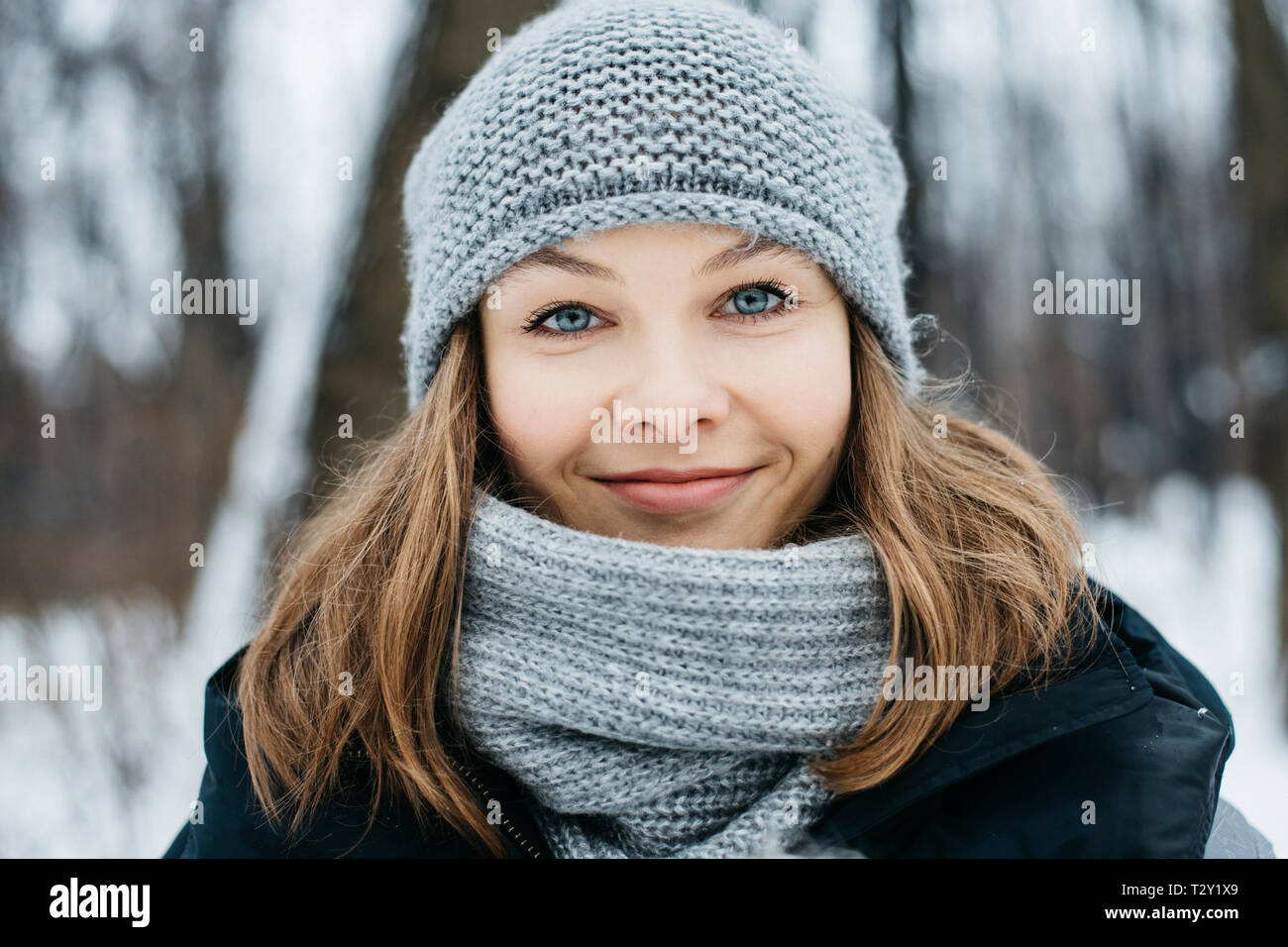 Closeup portrait of happy young woman in winter park looking at camera Banque D'Images