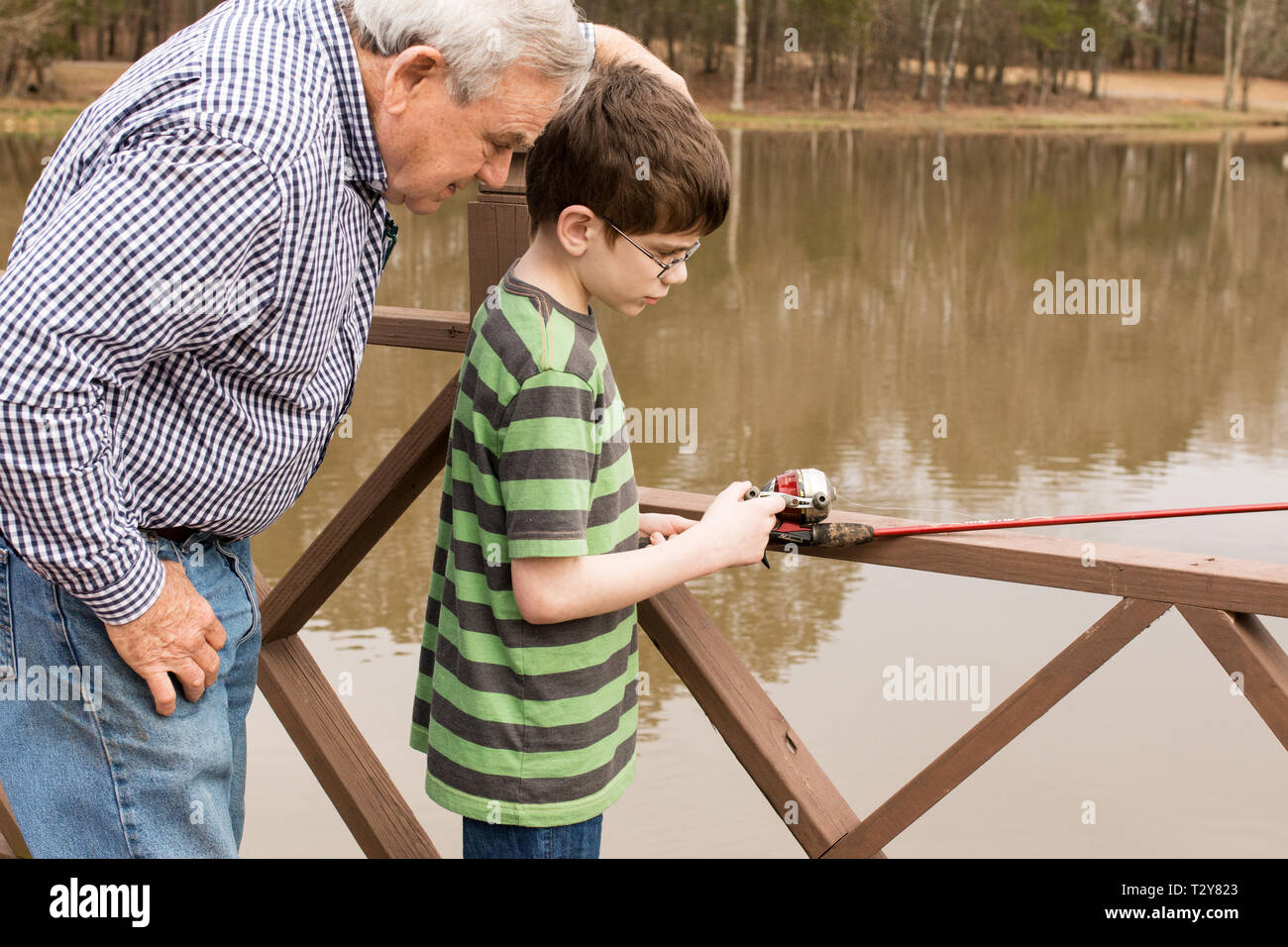 Un 11-année-vieux garçon apprendre à pêcher avec son grand-père sur un lac dans la région de Madison, Mississippi, USA. Banque D'Images