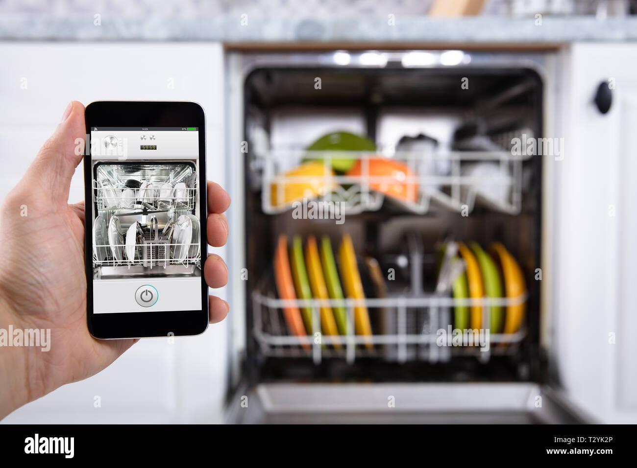Close-up of a person's Hand lave-vaisselle d'exploitation avec Smartphone Banque D'Images