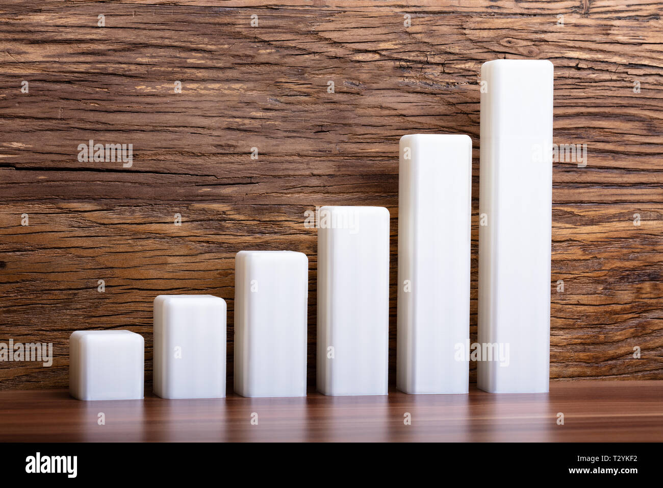 Graphique à barres 3d blanc réfléchissant sur la surface en bois Banque D'Images