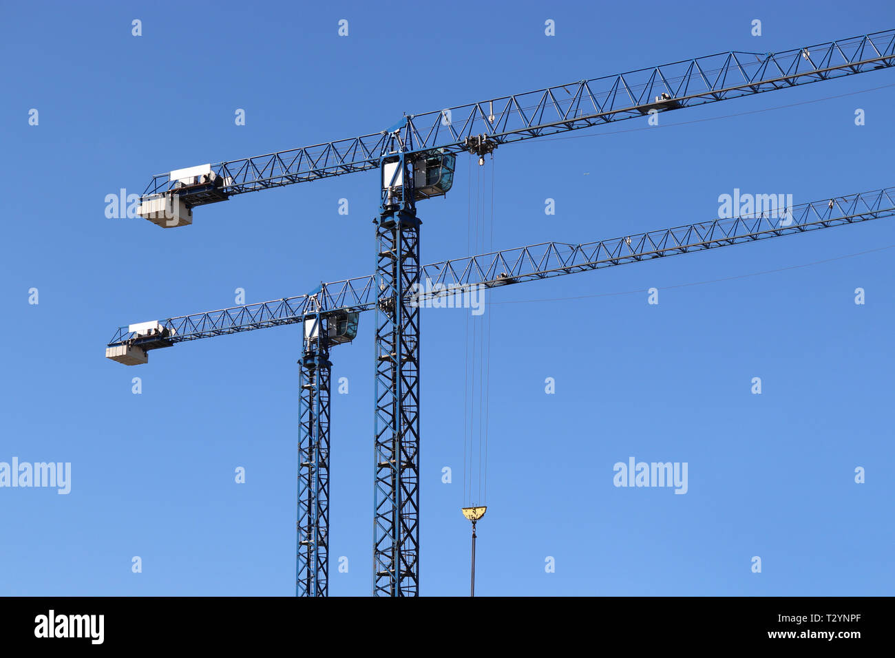 Les grues de construction sur fond de ciel bleu clair Banque D'Images