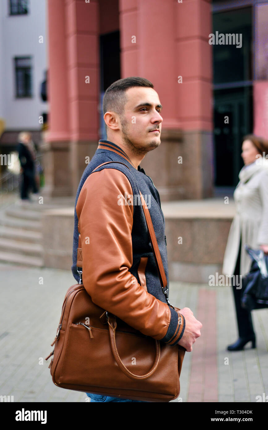 Portrait d'homme tenant un sac en cuir sur son épaule. le mec est dans la  rue Photo Stock - Alamy