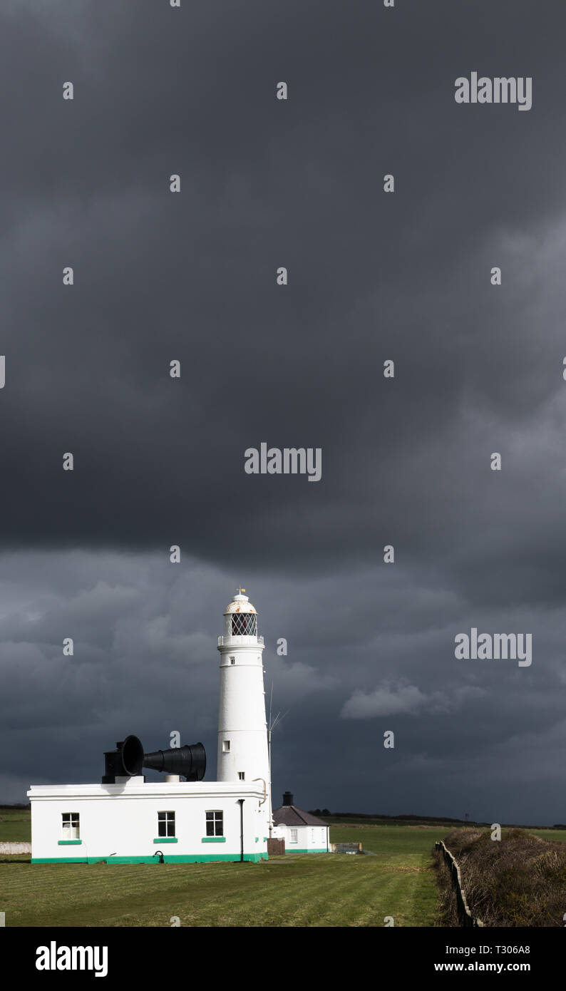 Le Nash Point Lighthouse sur Bristol Channel contre un ciel sombre sur la côte du Glamorgan au sud du Pays de Galles dans un format portrait. Banque D'Images
