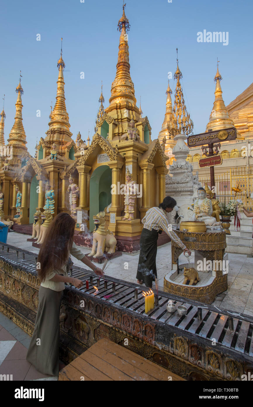 Les dévots bouddhistes birmans et l'encense herbal éclairage echelle artefacts au saint de la pagode Shwedagon, Yangon, Myanmar (Birmanie). Banque D'Images
