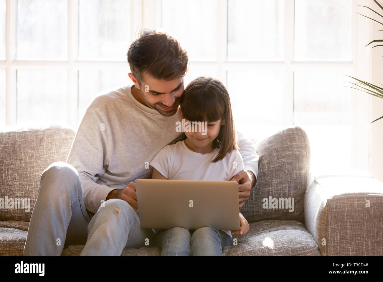 Père passer du temps libre avec une belle fille à l'aide d'ordinateur portable Banque D'Images