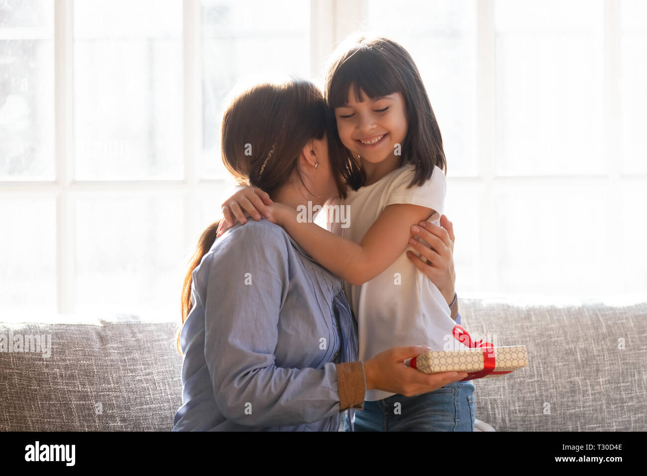 Mère embrassant fille exprimant leur gratitude pour cadeau reçu Banque D'Images