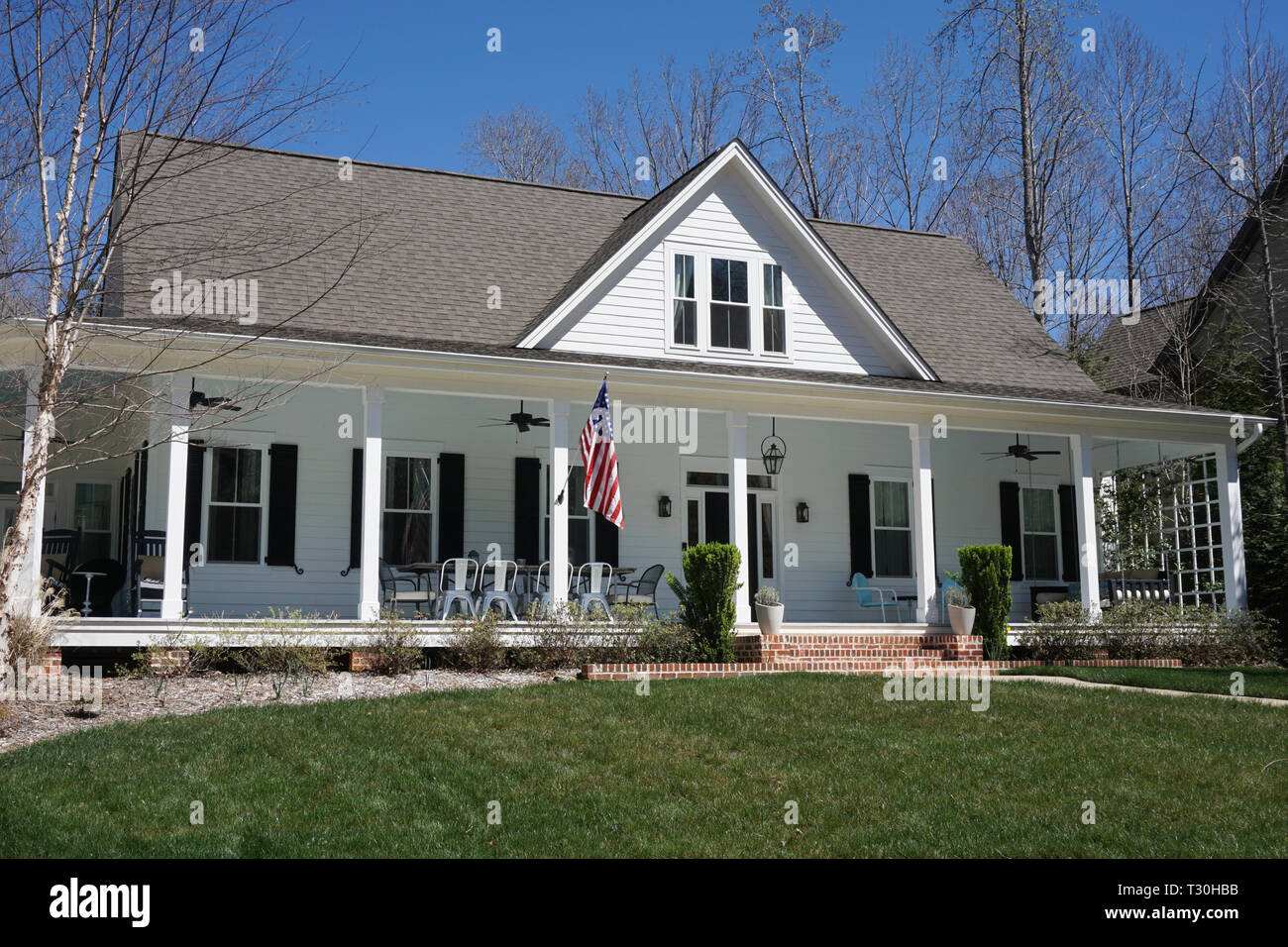 Maison de banlieue avec extérieur blanc et un porche Banque D'Images