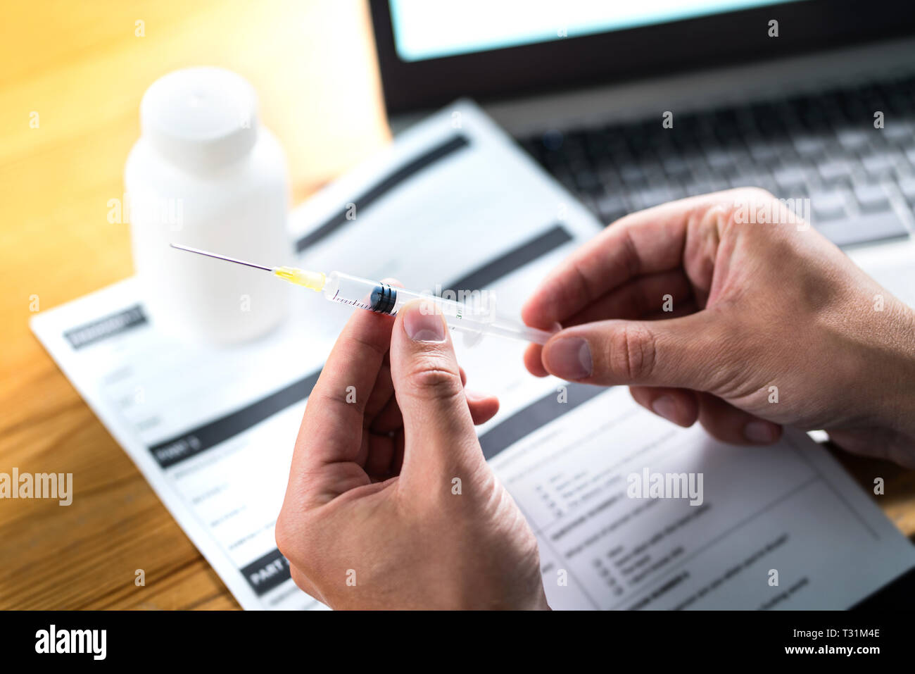 Le médecin ou le médecin qui tient l'aiguille d'injection dans une lumière dramatique. Recherche médicale. Document de dossier de soins de santé ou document de rapport sur le tableau. Banque D'Images