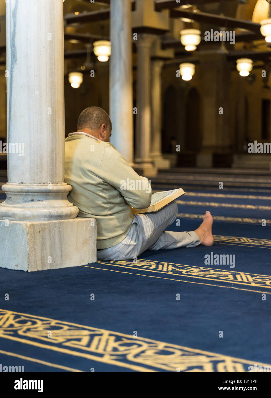 Un musulman en récitant le saint Coran livre dans une mosquée Banque D'Images