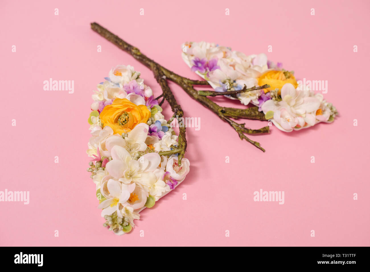 Composition florale avec des fleurs et des rameaux en forme de poumons sur Rose Banque D'Images