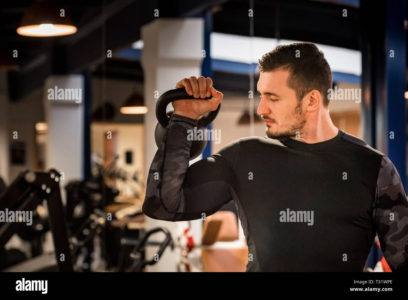 Athlète masculin attrayant faisant de l'exercice avec haltère biceps Banque D'Images