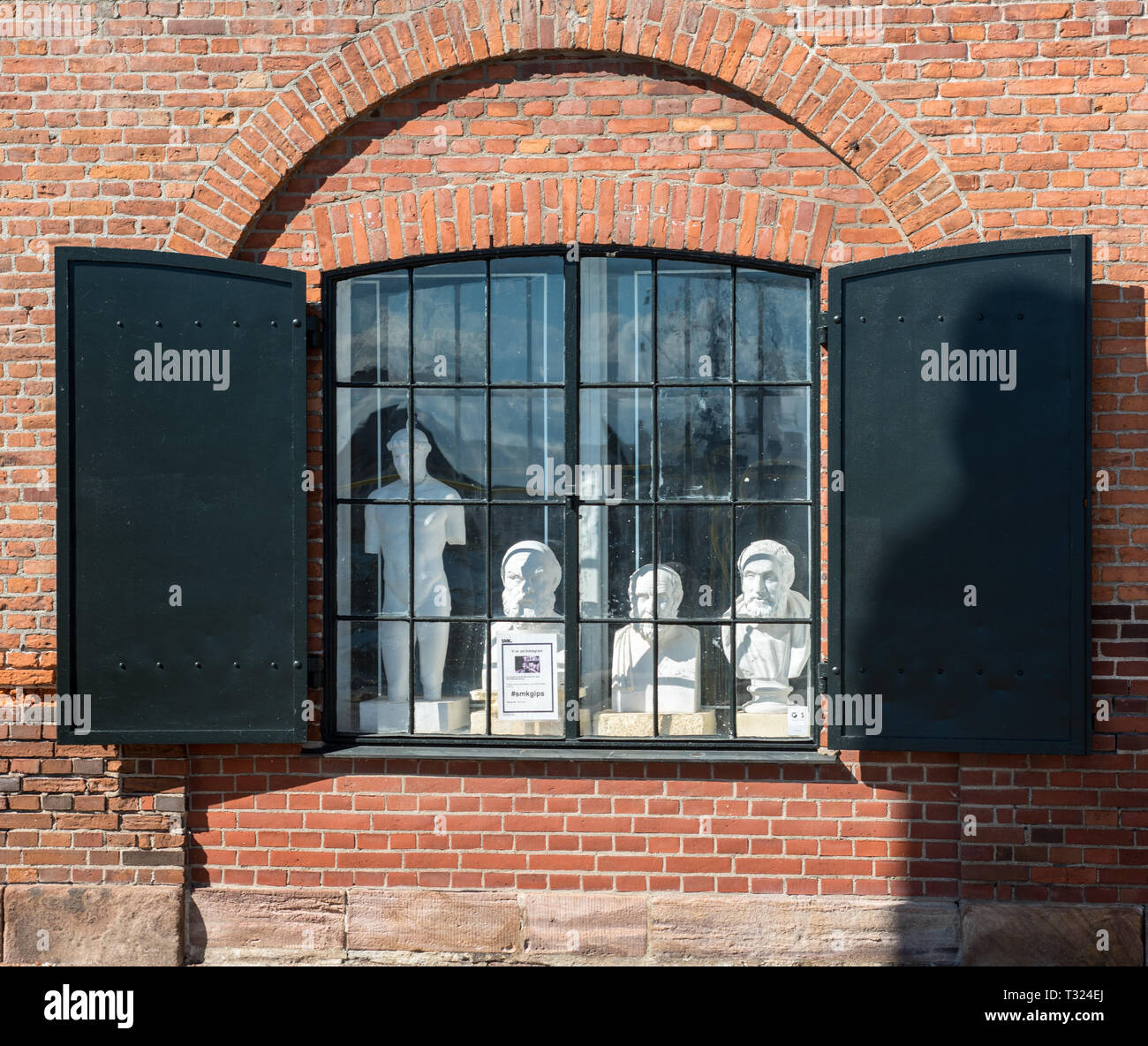 Plâtre de pairs chefs à travers la fenêtre à volets de Den b comme Afstøbningssamling art gallery de Toldbodgade, Copenhague Banque D'Images