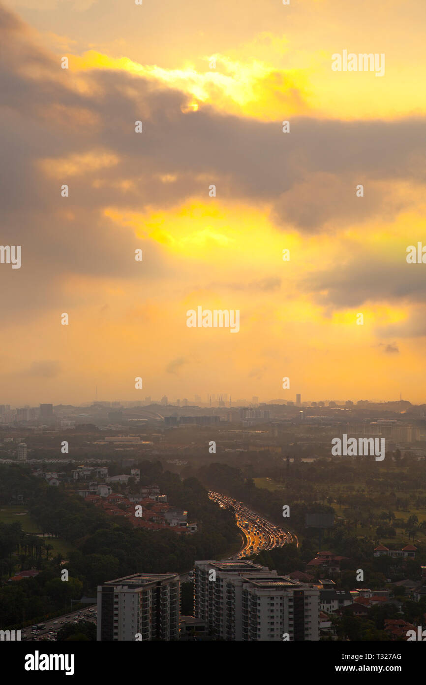 La ville de Kuala Lumpur, Malaisie, le coucher du soleil Vue générale montrant les navetteurs voiture accueil en route, mosquée silhouette sur l'horizon. Banque D'Images