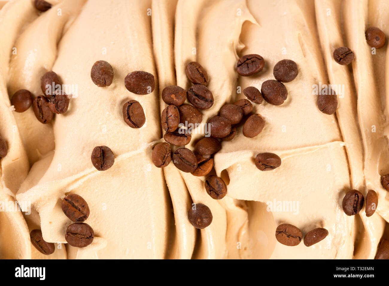 De nombreux grains de café sur la crème glacée close-up. Banque D'Images