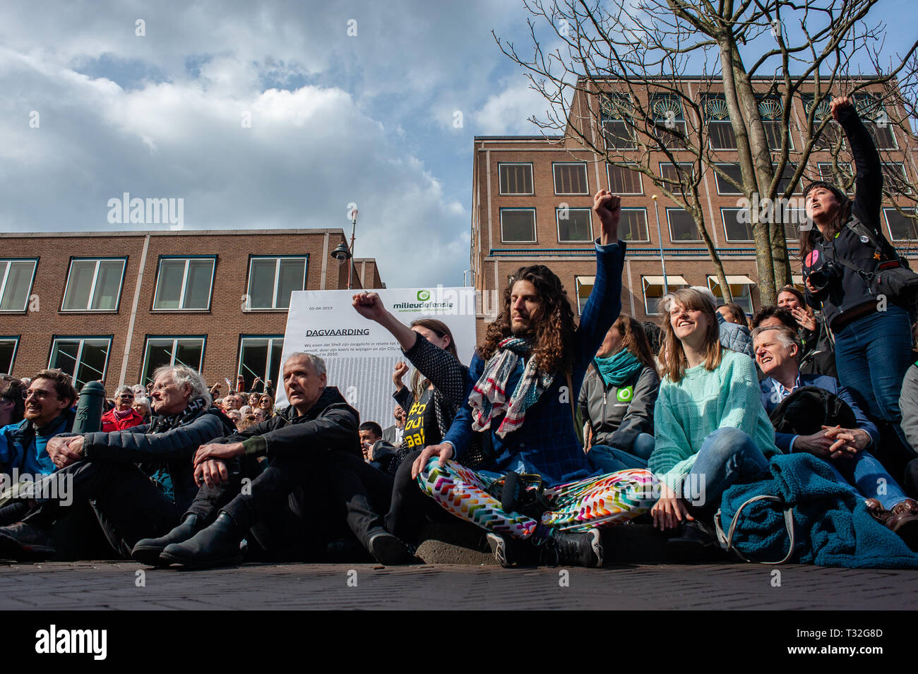Les protestataires sont vus posant à côté d'un placard plein de signatures en face de l'immeuble de la Shell au cours de l'anti-Shell démonstration. Des centaines de personnes rassemblées au Malieveld. De là, ils marchèrent jusqu'au siège de l'industrie du pétrole et du gaz société Shell pour effectuer une livraison de plus de 13 000 signatures à l'appui de citoyens néerlandais la poursuite. Ce serait une nouvelle approche juridique dans la lutte contre le changement climatique, la première poursuite de contester directement le modèle d'affaires et stratégie de croissance d'une société pétrolière. Sept organisations de l'environnement et des droits de l'homme dans l'Netherla Banque D'Images