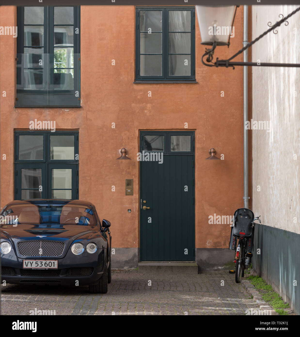 Mon autre véhicule est un vélo. Une Bentley et un vélo à l'extérieur d'une maison de couleur ocre à Kronprinsessegade, Copenhague Banque D'Images