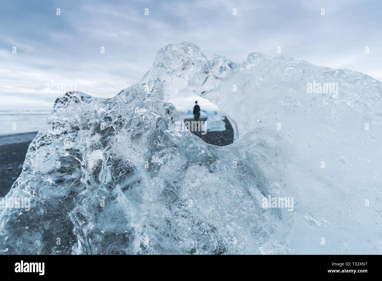 À l'intermédiaire d'un iceberg détaillée magnifiquement sur plage Jokulsarlon en Islande, une personne hors foyer est seul. Banque D'Images À l'intermédiaire d'un iceberg détaillée magnifiquement sur plage Jokulsarlon en Islande, une personne hors foyer est seul. Banque D'Images
