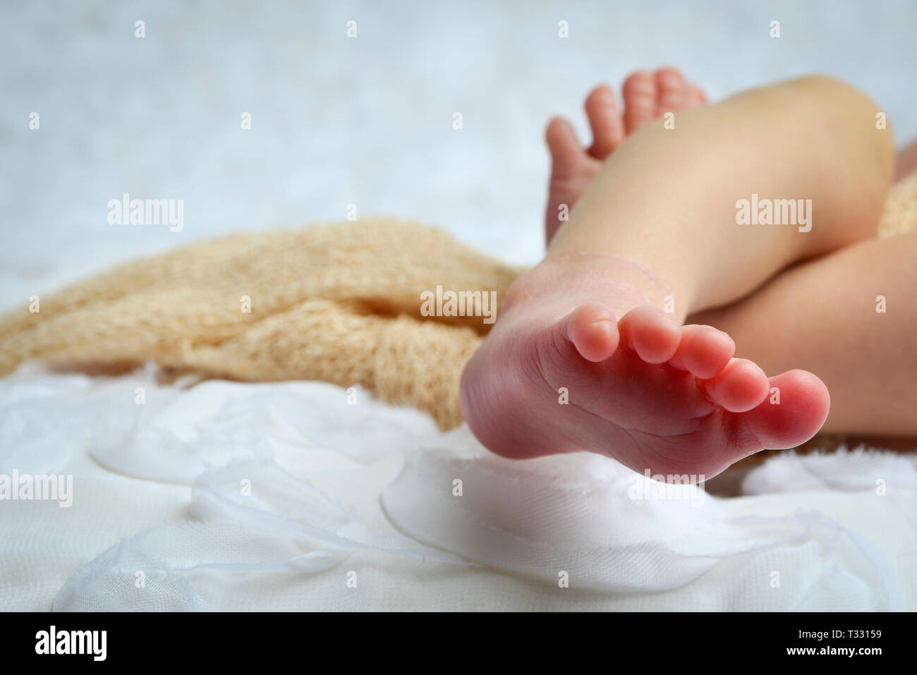 Un portrait Portrait d'un bébé nouveau-né des pieds et les pieds dans l'environnement de couleur neutre et blanc Banque D'Images