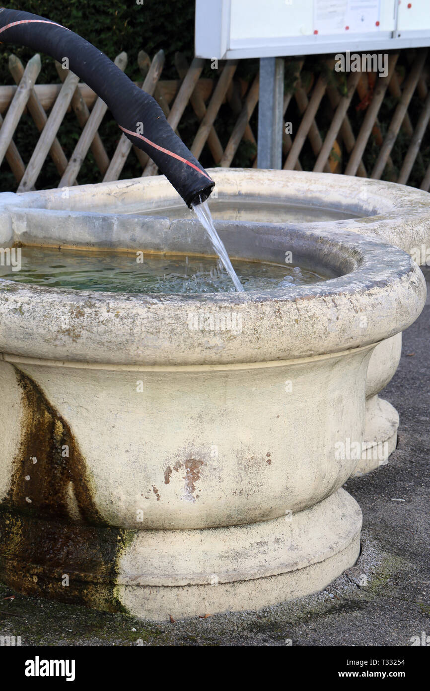 Détails d'une fontaine d'eau potable, à Nyon, en Suisse. Cette fontaine est  faite de beige clair et concret a vieux tuyau noir sous la forme d'un  onglet Photo Stock - Alamy