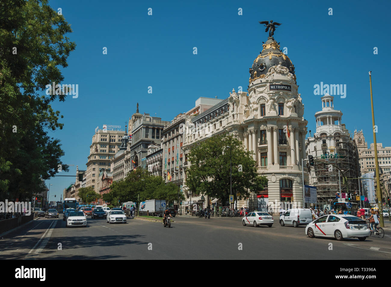 Les vieux bâtiments sur l'animée rue Alcala avec les gens et les voitures, dans une journée ensoleillée à Madrid. Capitale de l'Espagne avec dynamisme et vie culturelle intense. Banque D'Images