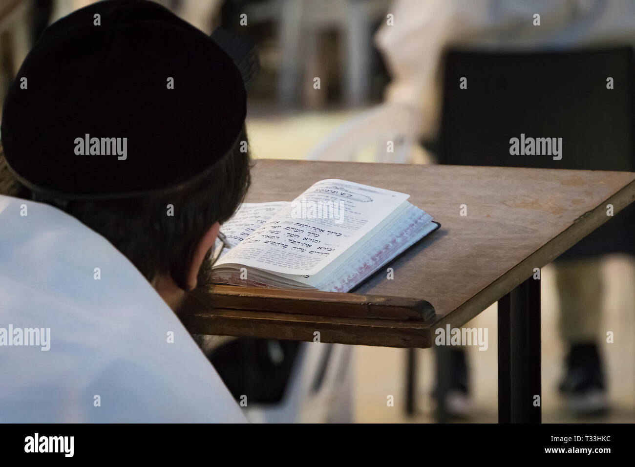 Un homme religieux en train de lire une torah au Mur des lamentations. Lecture du livre saint du judaïsme au mur occidental dans la vieille ville de Jérusalem. Chef de la t Banque D'Images